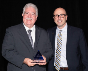 El doctor Benjamín Colucci Ríos recibe la distinción a manos de Bruce Boomer, presidente del Instituto de Ingenieros en Transportación (ITE).