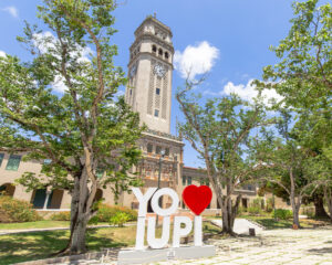Torre de la UPR Recinto de Río Piedras con una pancarta al frente de letras e iconos que lee "Yo amo iupi".