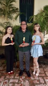 La estudiante Erica N. Arocho Pérez y Yadeliz López Rodríguez junto al director de Teatro Universitario UPRAg, el profesor Alberto Martínez Marquez durante la ceremonia de premiación.