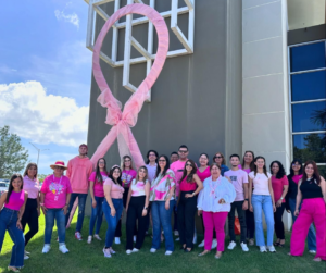 Parte de la comunidad universitaria junto al lazo rosa en concienciación del cáncer de mama