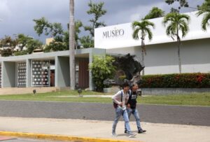 Dos estudiantes pasando por el frente del Museo de la Universidad de Puerto Rico Recinto de Río Piedras