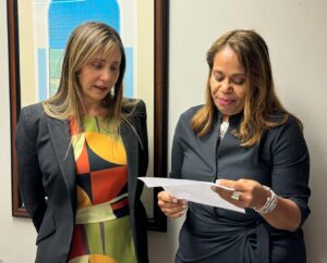 doctora Myrna L. Quiñones Feliciano al lado de a la doctora Debora H. Silva Díaz que está leyendo un certificado.