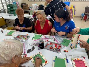 Adultos mayores haciendo manualidades con tutora