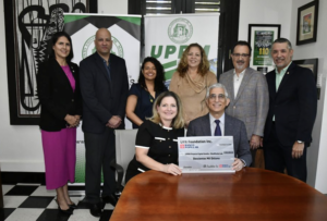 Dra. Leila Marcano Nieves recibiendo un cheque simbólico del Banco Popular.