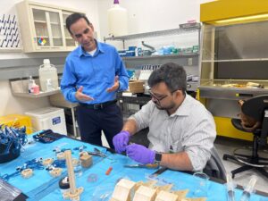 Dr. David Suleiman Rosado y Juan Camilo Rivera Díaz trabajando en una mesa de laboratorio