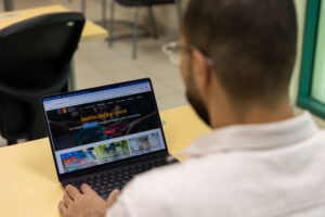 Estudiante con laptop matriculándose en un curso.