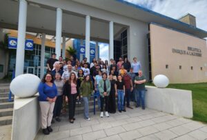 Grupode estudiantes y profesores posando frente a la biblioteca Enrique A. Laguerre, en la UPR en Aguadilla